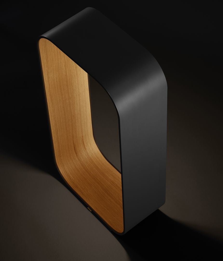 Rounded rectangle of bent plywood with light shining from inside against a black background