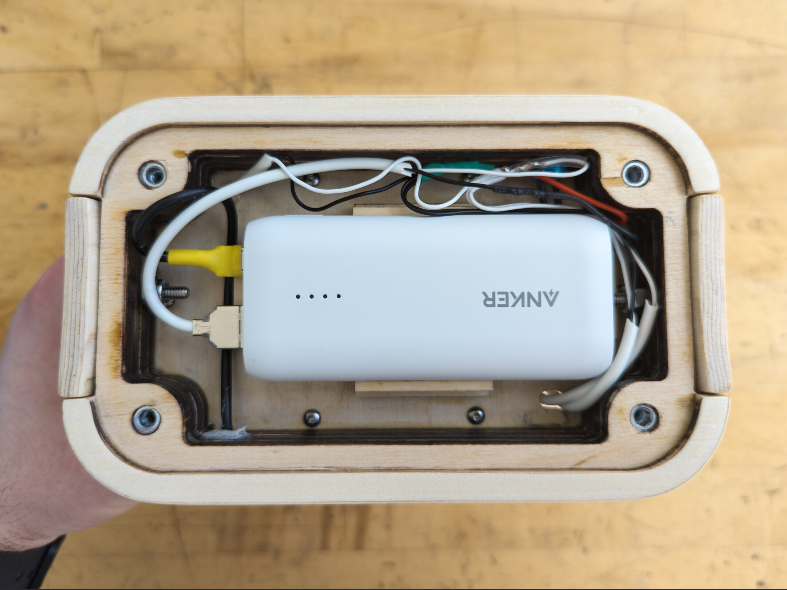 Closeup of wiring and battery of wood lantern with baseplate removed